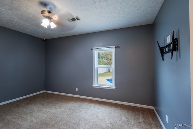 spare room with a textured ceiling, carpet, and ceiling fan