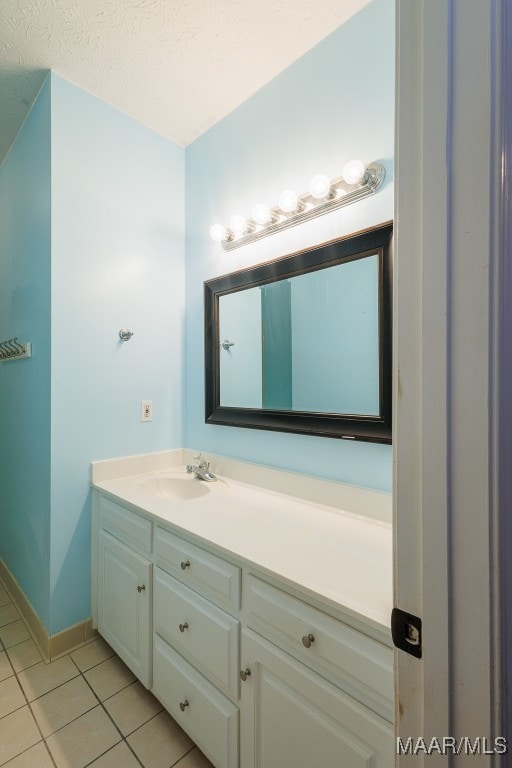 bathroom featuring tile patterned floors, a textured ceiling, and vanity