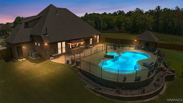 pool at dusk with central AC unit, a yard, and a patio