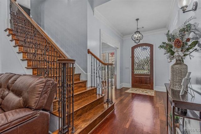 entrance foyer featuring crown molding, dark wood-type flooring, and a chandelier