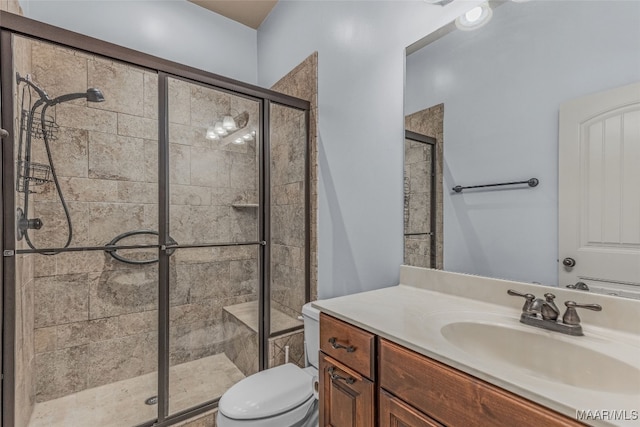 bathroom with vanity, toilet, and a shower with shower door