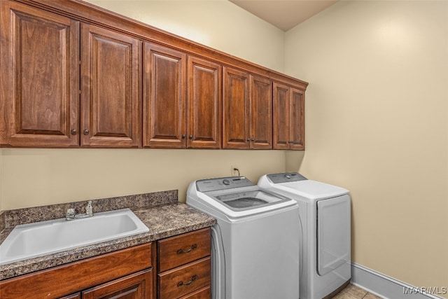 clothes washing area featuring cabinets, washer and clothes dryer, and sink