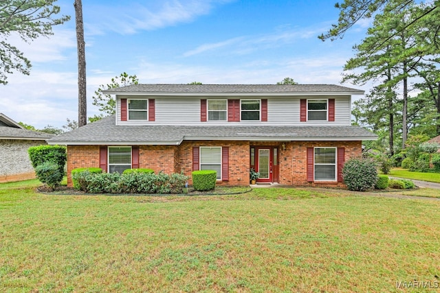 traditional-style home featuring brick siding, a front yard, and a shingled roof