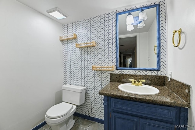 bathroom with vanity, tile patterned floors, toilet, and baseboards