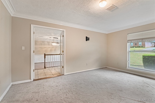 spare room featuring carpet flooring, a textured ceiling, and ornamental molding