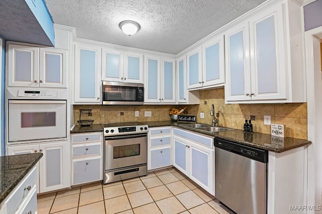 kitchen featuring sink, white cabinetry, stainless steel appliances, and light tile patterned floors