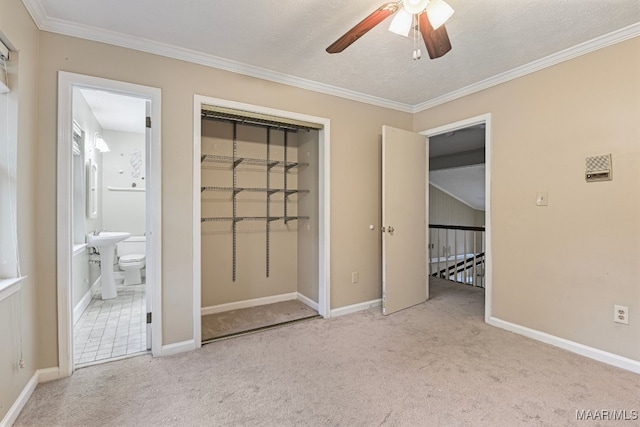 unfurnished bedroom featuring connected bathroom, light carpet, ornamental molding, and a closet