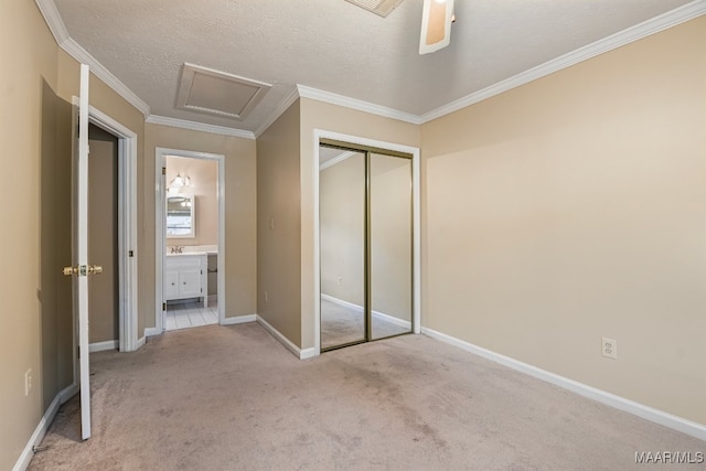 unfurnished bedroom with a textured ceiling, a closet, ceiling fan, light carpet, and ornamental molding