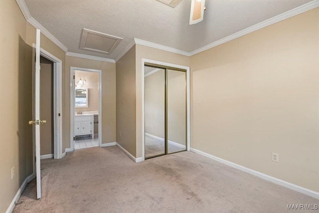 unfurnished bedroom featuring attic access, carpet, and ornamental molding