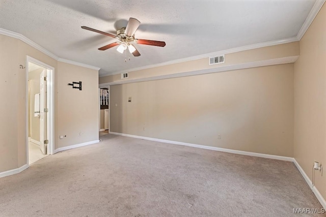 carpeted spare room with baseboards, visible vents, ceiling fan, a textured ceiling, and crown molding