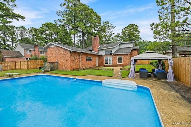 view of swimming pool featuring a gazebo, a lawn, a fenced in pool, and a fenced backyard