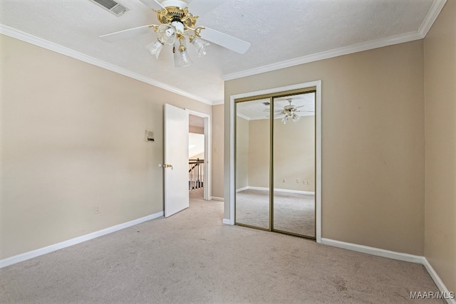 unfurnished bedroom featuring a closet, ornamental molding, light colored carpet, and ceiling fan