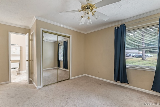 unfurnished bedroom featuring a closet, ornamental molding, carpet, a textured ceiling, and ceiling fan