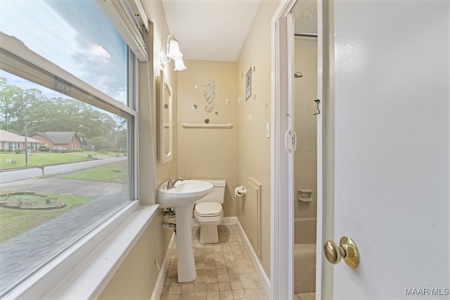 bathroom with toilet, a healthy amount of sunlight, and tile patterned flooring