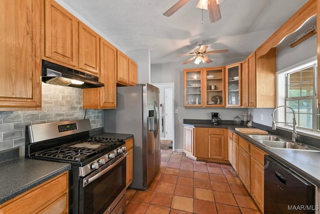 kitchen with appliances with stainless steel finishes, tile patterned flooring, sink, decorative backsplash, and ceiling fan