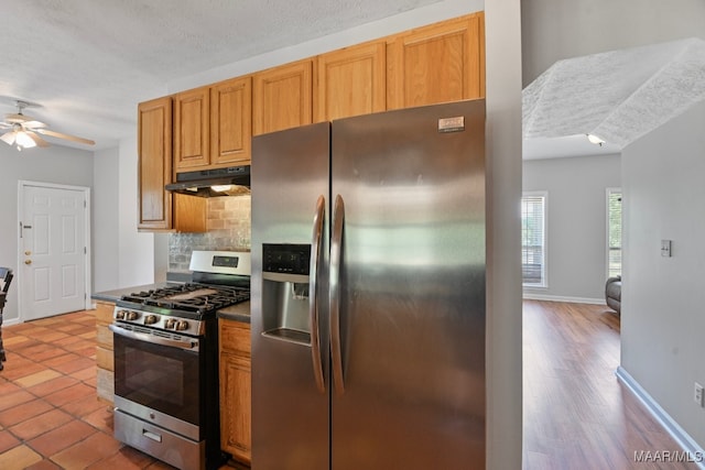 kitchen with light wood-type flooring, a textured ceiling, stainless steel appliances, and ceiling fan