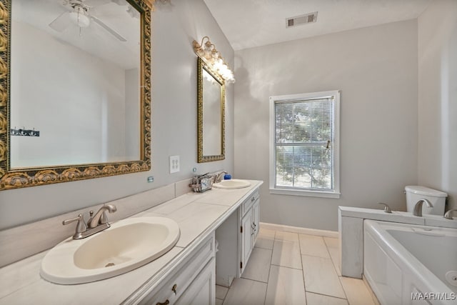 bathroom featuring vanity, a tub, tile patterned flooring, toilet, and ceiling fan