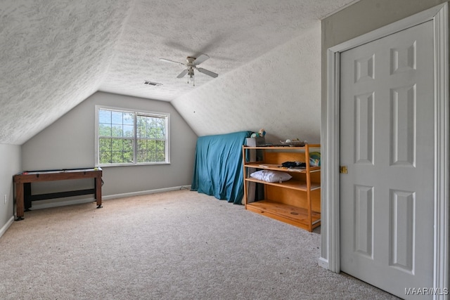 additional living space with lofted ceiling, ceiling fan, carpet floors, and a textured ceiling