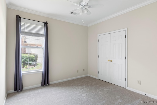 unfurnished bedroom featuring multiple windows, crown molding, light carpet, and ceiling fan