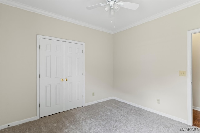 unfurnished bedroom with a closet, ceiling fan, carpet floors, and crown molding