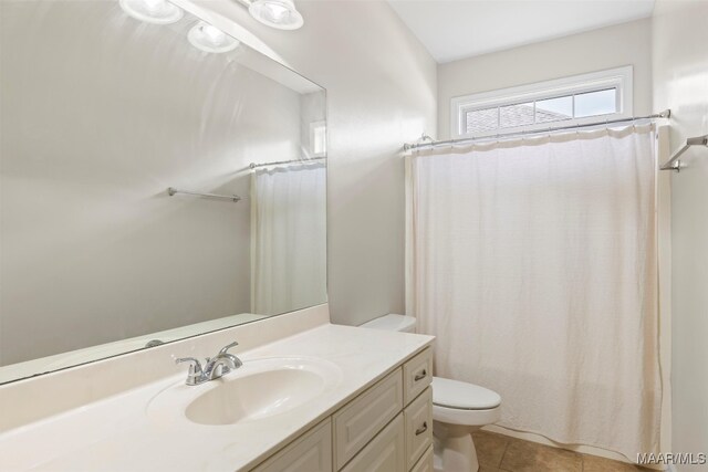 bathroom with curtained shower, tile patterned flooring, vanity, and toilet