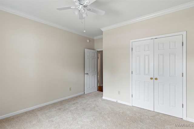 unfurnished bedroom featuring crown molding, ceiling fan, light colored carpet, and a closet