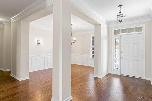 entrance foyer featuring a chandelier, dark hardwood / wood-style floors, and crown molding