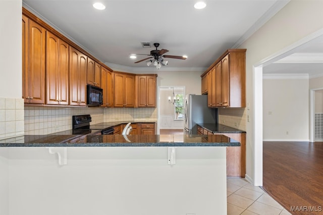 kitchen with light hardwood / wood-style floors, kitchen peninsula, black appliances, ceiling fan, and ornamental molding