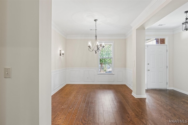 unfurnished room with ornamental molding, a chandelier, and dark wood-type flooring