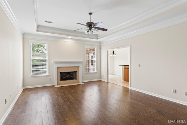 unfurnished living room with a raised ceiling, ornamental molding, ceiling fan, and hardwood / wood-style flooring