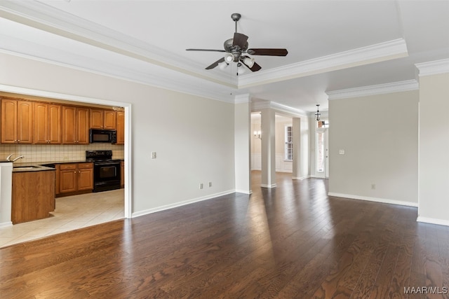 unfurnished living room with ceiling fan, a raised ceiling, crown molding, and light hardwood / wood-style floors