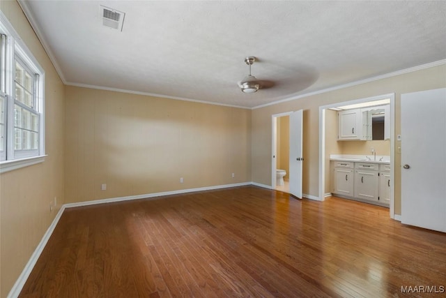 1300 Melanie Ln, Phenix City, AL 36867 - unfurnished living room with crown molding, hardwood / wood-style floors, baseboards, a sink, and visible vents