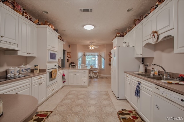 kitchen with white cabinets, white appliances, kitchen peninsula, and ceiling fan