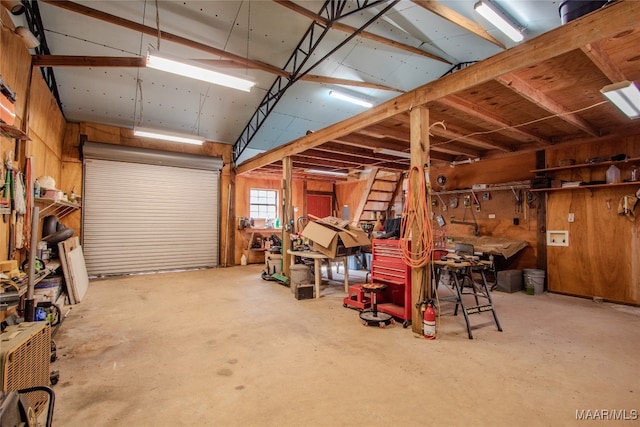 garage with wood walls and a workshop area