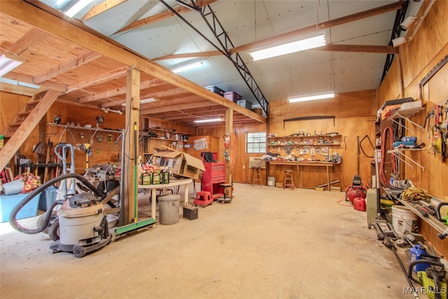 garage with a workshop area and wooden walls