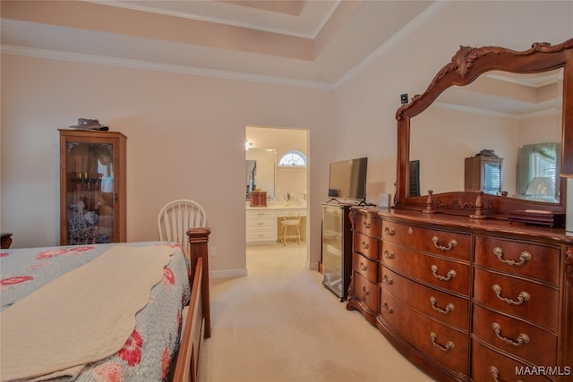 carpeted bedroom featuring connected bathroom, ornamental molding, and a tray ceiling