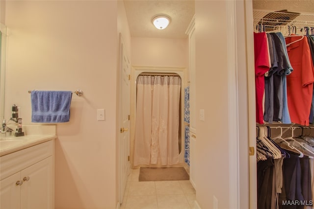 bathroom featuring a textured ceiling, vanity, and tile patterned flooring