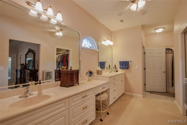 bathroom featuring ceiling fan, a textured ceiling, and vanity