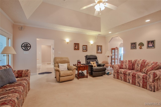 living room featuring carpet flooring, ceiling fan, a raised ceiling, and ornamental molding