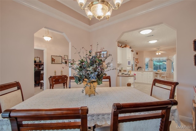 dining space featuring crown molding, ceiling fan with notable chandelier, and light colored carpet