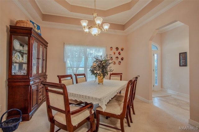 dining area featuring ornamental molding, plenty of natural light, a notable chandelier, and a tray ceiling