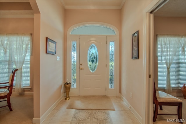 entrance foyer featuring a wealth of natural light, light tile patterned flooring, and ornamental molding