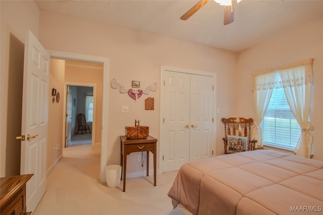 carpeted bedroom featuring ceiling fan and a closet