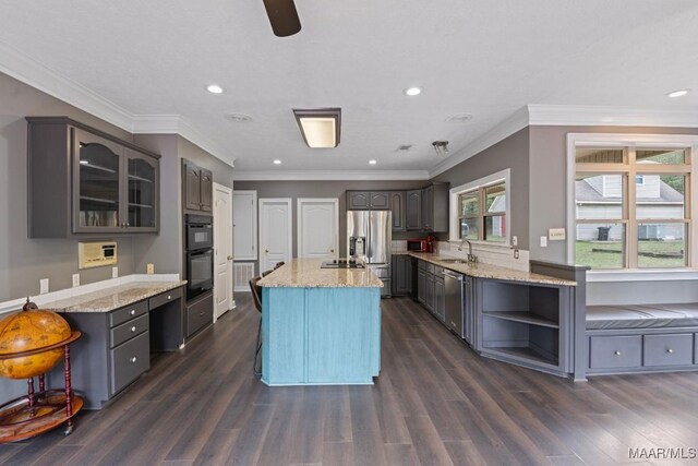 kitchen featuring light stone counters, a center island, dark hardwood / wood-style floors, sink, and stainless steel appliances