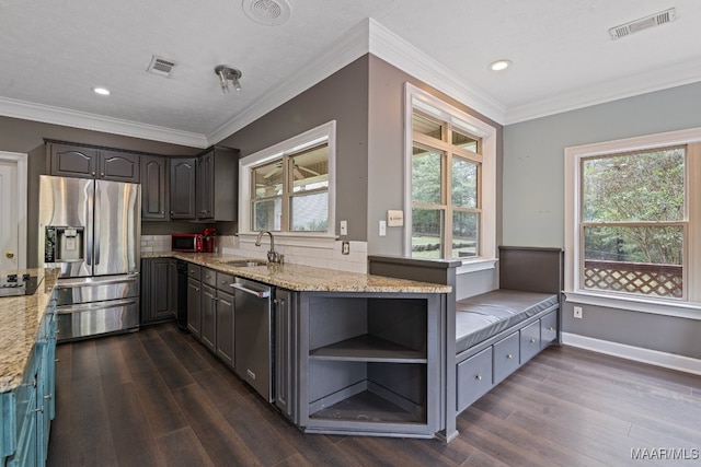 kitchen with light stone counters, appliances with stainless steel finishes, and dark wood-type flooring