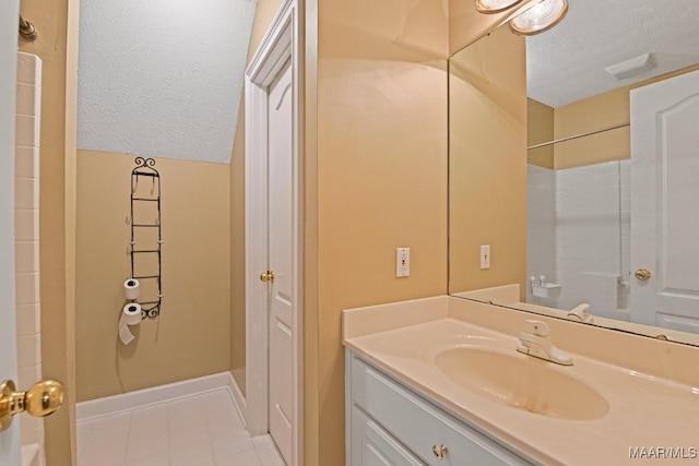 bathroom featuring a textured ceiling, vanity, and walk in shower