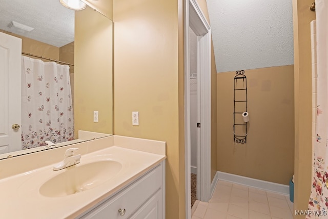 bathroom featuring a textured ceiling, vanity, and tile patterned floors