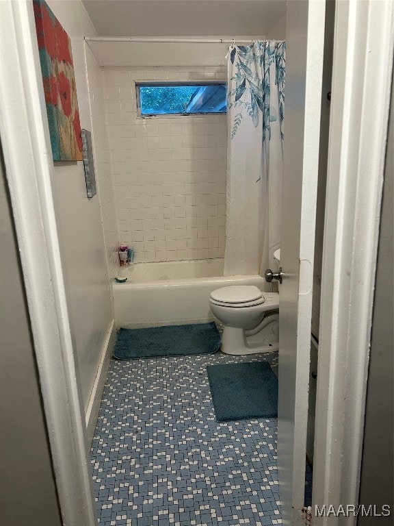 bathroom featuring shower / bath combo with shower curtain and toilet