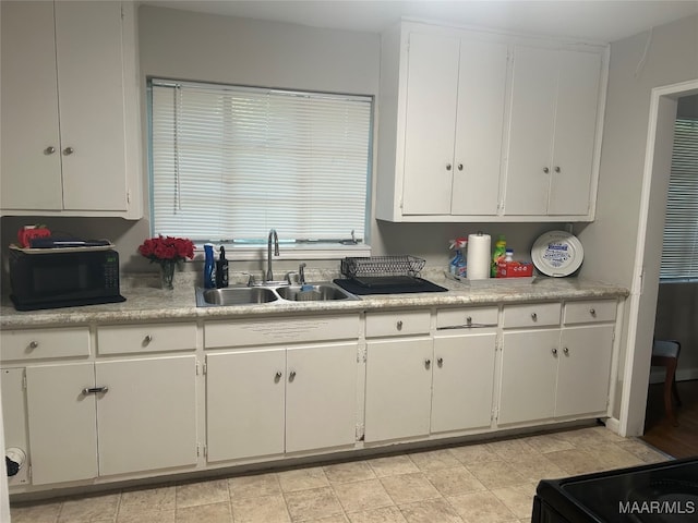 kitchen featuring white cabinets, sink, and black appliances