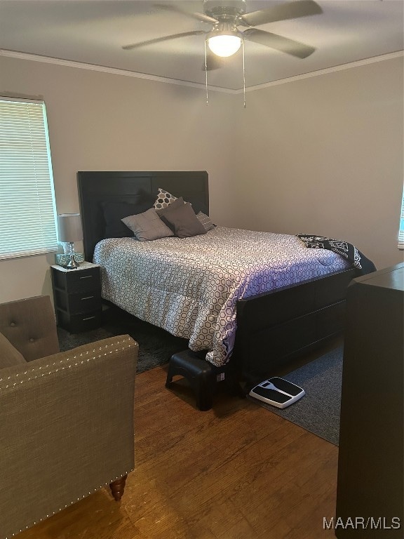 bedroom featuring wood-type flooring, crown molding, and ceiling fan